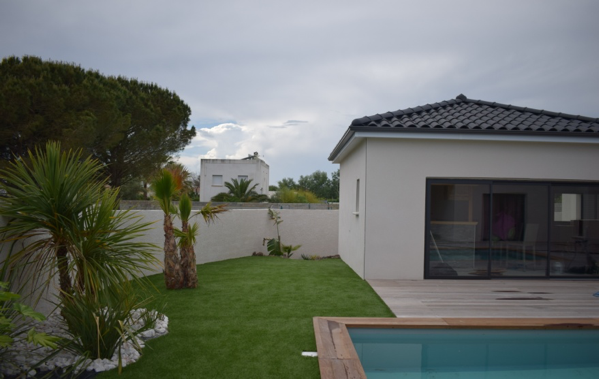 Jardin paysagé avec piscine bois et gazon synthétique sur la commune de Arles.